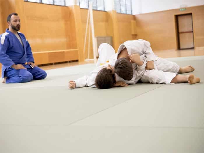 Marco, the owner of Black Rock Martial Arts, high fives a young girl martial arts student.